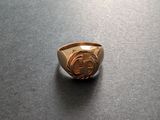 un gros plan d'une bague en or sur laquelle figure le symbole du dollar