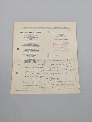 un vieux document sur lequel figure une lettre manuscrite, posé sur une table