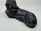 a statue of a dog laying down on a table