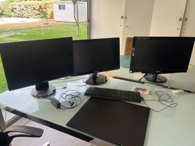 two computer monitors sitting on a desk with a mouse and keyboard