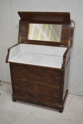 un coffre en bois surmonté d'un miroir