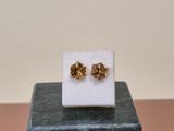the small gold bow stud earrings are on top of a marble block