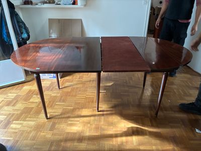 un homme debout devant une table sur laquelle se trouvent deux feuilles