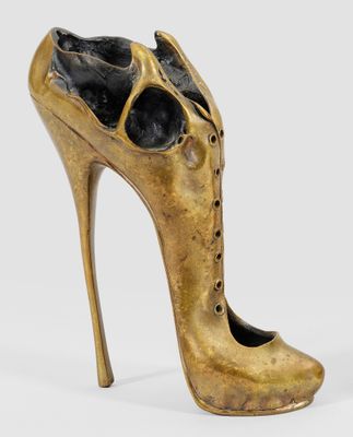 une image représentant une sculpture en bronze représentant une chaussure, sur fond blanc