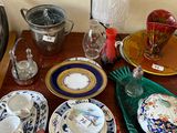 de nombreuses assiettes et tasses sur une table éclairée par une lampe