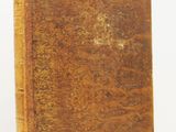 an old book sitting on top of a white surface