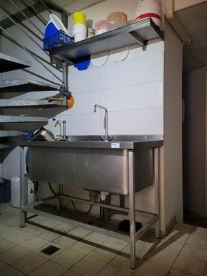 a stainless steel sink in a kitchen next to a staircase