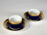 deux tasses et soucoupes à bord doré sur fond blanc