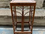 a small wooden table with a glass top on a sidewalk