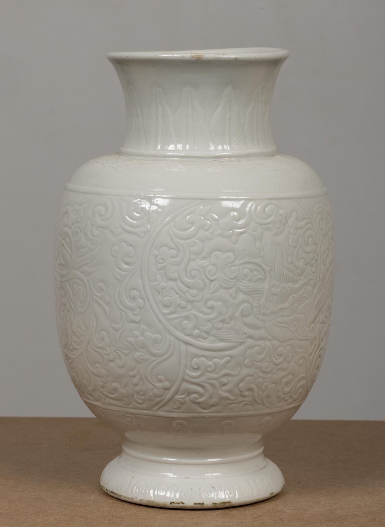 CHINE, XXème siècle. Vase balustre en porcelaine et émail blanc à décor incisé de dragons parmi les flots. H_47 cm D_...