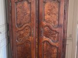 a wooden armoire in the corner of a room