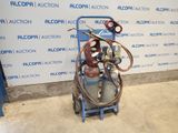 un chariot bleu sur lequel se trouvent un bidon d'essence et un tuyau