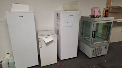 three refrigerators and a freezer in a room
