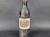 an old bottle of wine sitting on top of a table