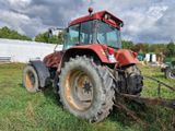 un tracteur rouge garé dans l'herbe