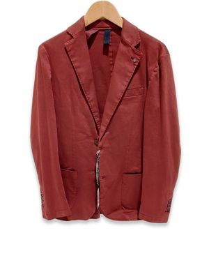 une veste rouge suspendue à un cintre en bois sur un mur blanc