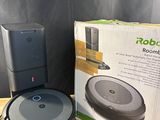 an open box of a robot vacuum sitting on top of a wooden table