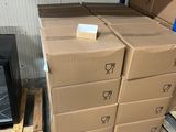 de nombreux cartons empilés sur des palettes dans un entrepôt