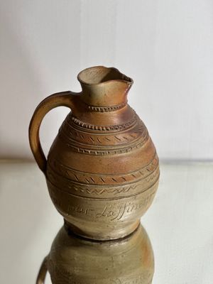 a brown vase sitting on top of a glass table