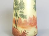 un vase avec un tableau posé sur une table