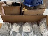 Des cartons contenant des casques de chantier sont empilés les uns sur les autres dans un entrepôt