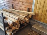 a pile of wood next to a wooden door