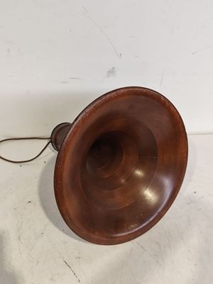une enceinte en bois à l'ancienne, avec un cordon, posée sur une surface blanche