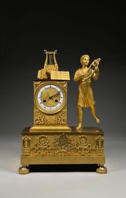PENDULE figurant un jeune éphèbe jouant de la lyre La façade…