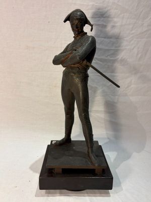 bronze statue of a man with a sword on a marble base