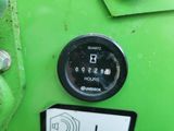 a close up of a green machine with a clock on it ' s side