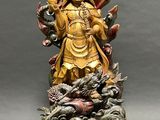 a gold statue of a woman with a dragon on her arm