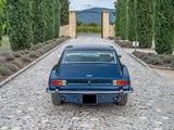 a blue car parked on a cobblestone road