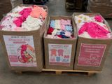 Des cartons de vêtements pour bébés sont empilés sur une palette dans un entrepôt