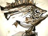 a fish sculpture made of metal on a stand