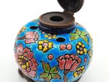 un petit vase bleu orné de fleurs peintes