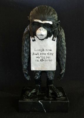 statue of a monkey holding a sign with a sign on it ' s head