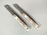 two pairs of scissors with floral designs on them sitting on a table