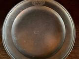 a silver plate sitting on a wooden table