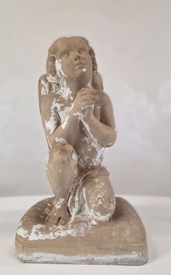 une petite statue représentant un enfant assis sur un bloc
