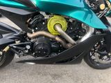 a green motorcycle parked on the side of the street