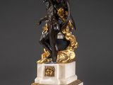 an antique bronze and marble statue of a man holding a sword