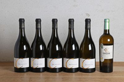 six bouteilles de vin sont alignées sur une table en bois