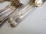 beaucoup de cuillères en argent et de cuillères à soupe sur une table