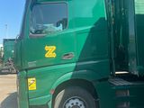 a green truck that is parked in a parking lot