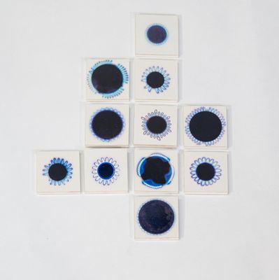 des sous-verres bleus et blancs en forme d'œil sur un fond blanc