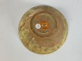 a brown bowl on a white surface with a yellow tag