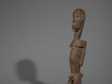 une statue représentant une personne debout sur un socle noir