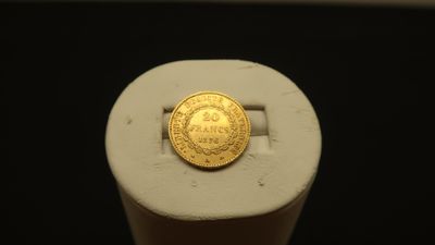 a gold coin sitting on top of a white stand