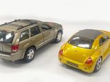 two toy cars sitting next to each other on a white surface