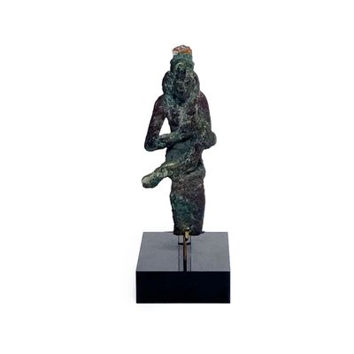 statue d'une femme tenant un oiseau, posée sur un socle noir